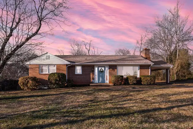 Front of the one-story brick house with a carport at sunset at 7130 Suncrest Drive, Lynchburg VA