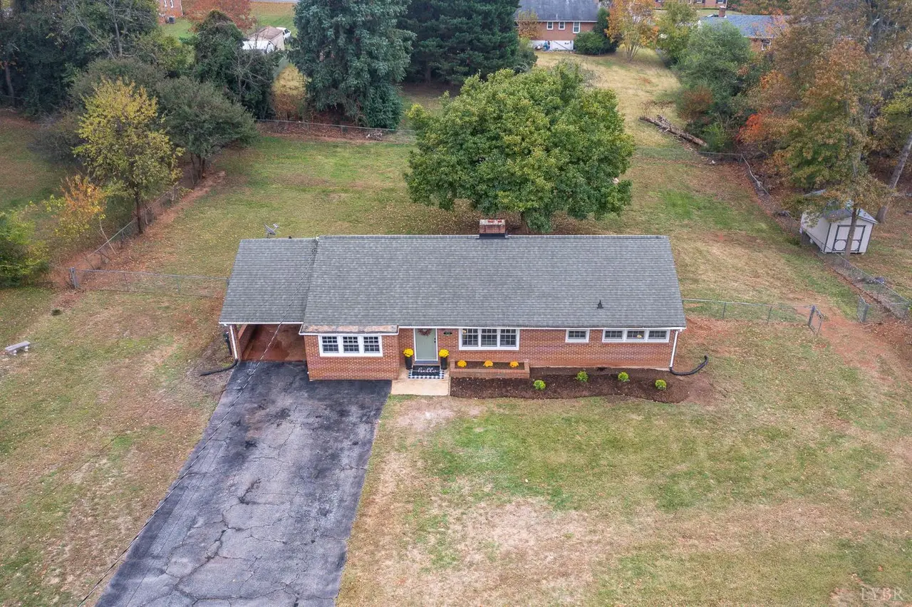Aerial view of the brick house with a carport and long driveway at 7133 Suncrest Drive, Lynchburg VA