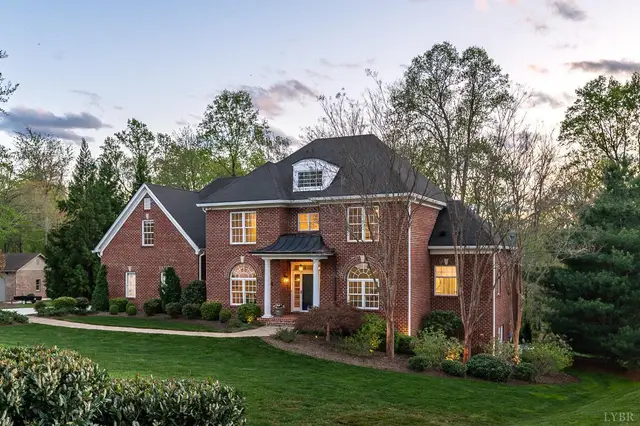 Front of the two-story brick house with landscaped beds at dusk at 1278 Jefferson Dr W, Forest VA