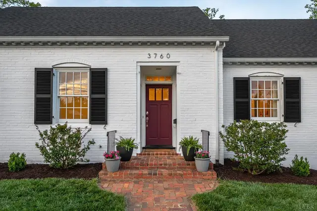 Red front door with black shutters and brick steps at 3760 Woodside Avenue, Lynchburg VA