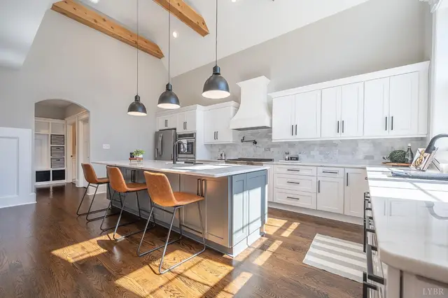 Kitchen island with leather bar stools and white cabinets at 801 Leander Drive, Forest VA
