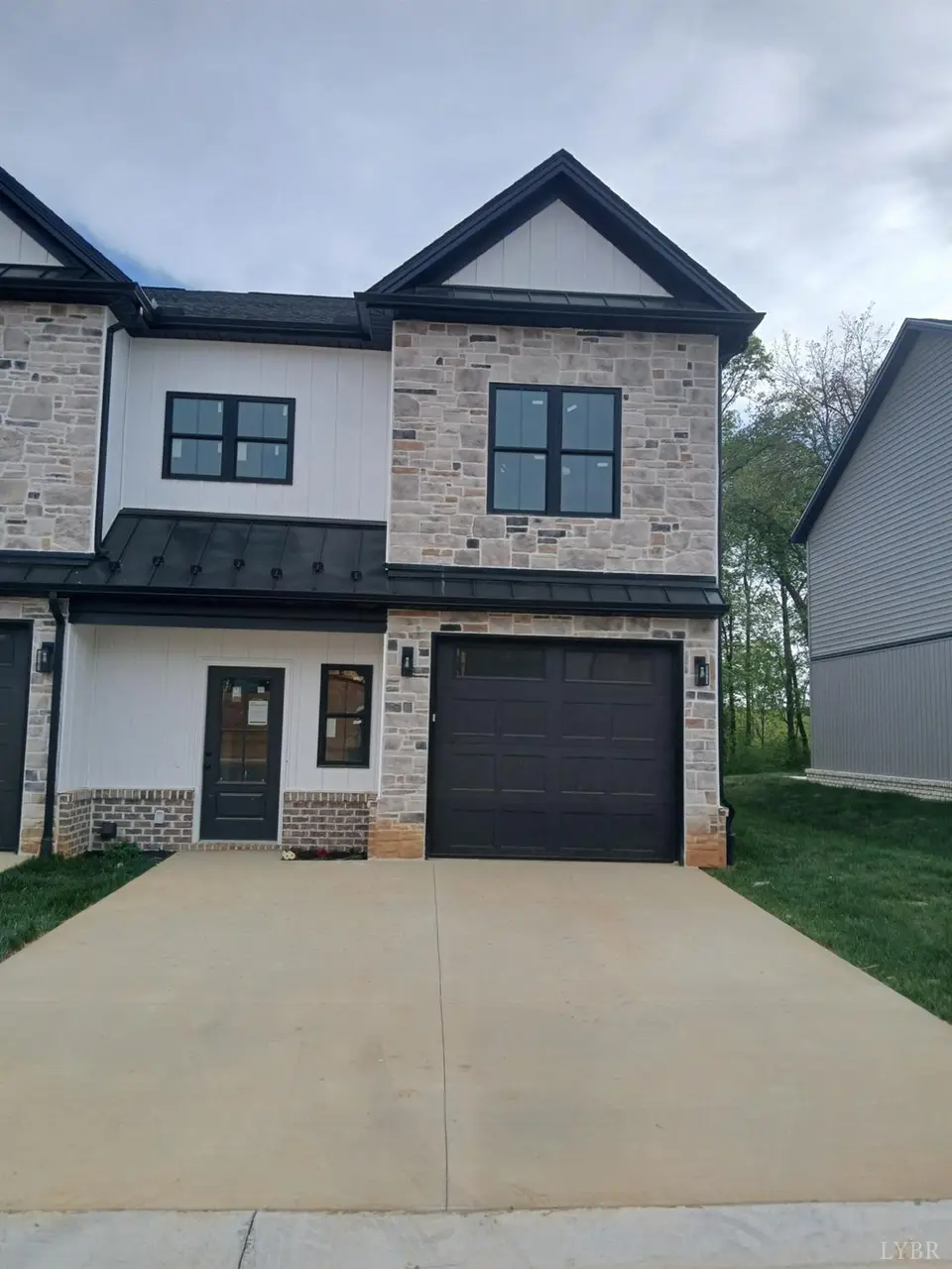 Front of the townhouse with stone accents and a one-car garage at 95 Luke Court, Rustburg VA