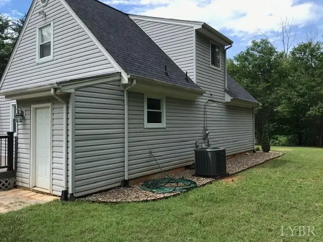 Side of the house with gray siding and a side door at 97 Settlers Row, Lynchburg VA